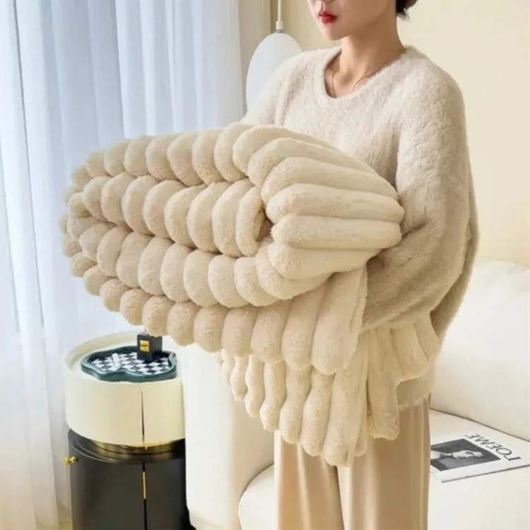 Faux-fur throw blanket in cream with a striped design, showing the plush pile