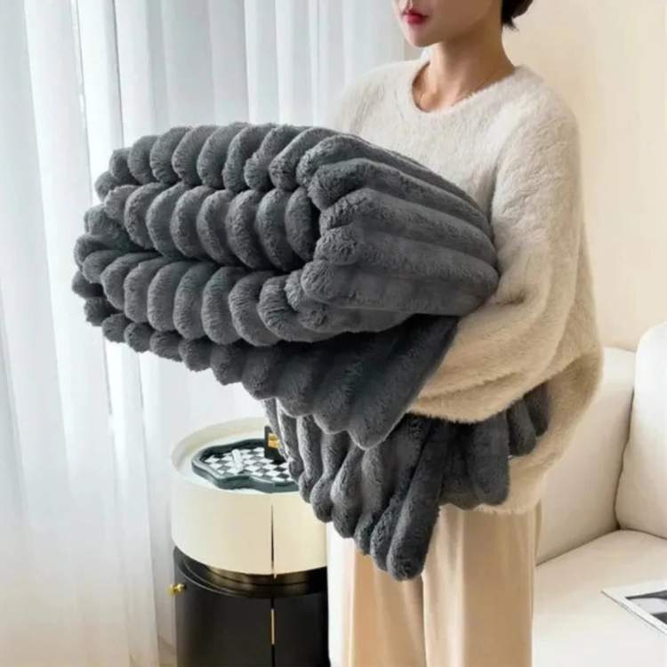 Faux-fur throw blanket in dark gray with a striped design, close-up of the stripe