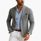 Grey tailored blazer with classic lapel and patch pockets, shown front view