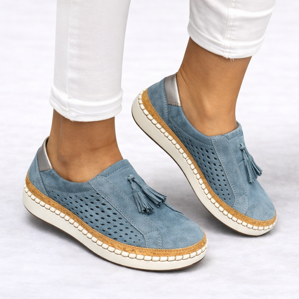 Orthopedic slip-on shoes in blue with breathable perforated panels and tassel detail.