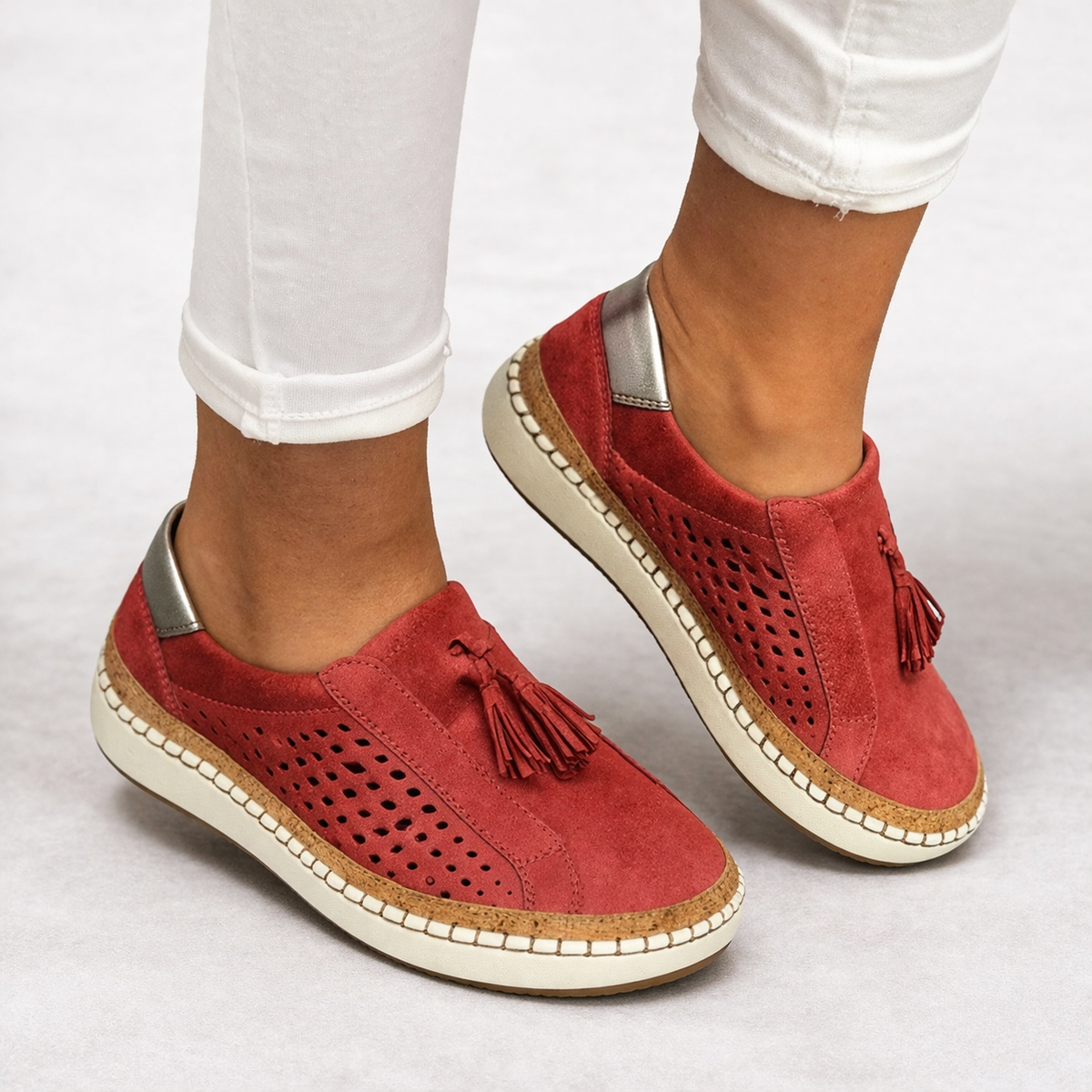 Orthopedic slip-on shoes in red with breathable perforated panels and tassel detail.