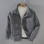 Grey padded corduroy jacket with full-zip front and deep pockets, warm winter outerwear