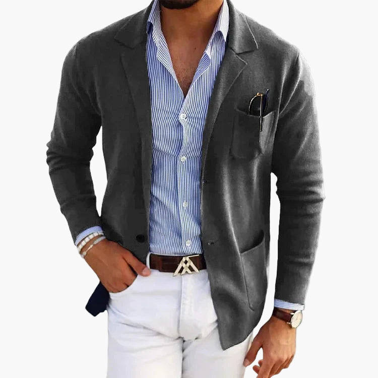 Dark grey tailored blazer with classic lapel and patch pockets, detail of chest pocket