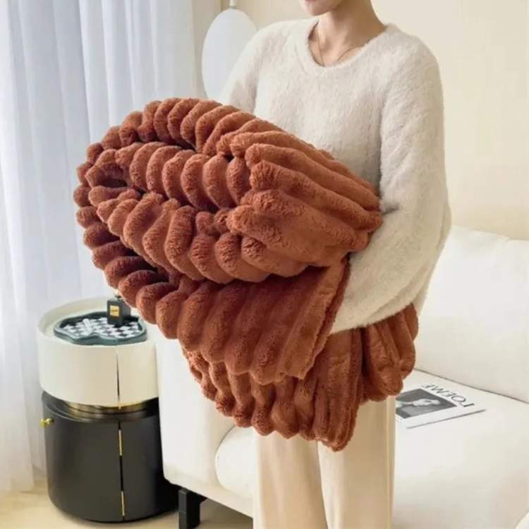 Faux-fur throw blanket in brown with a striped design, shown as a sofa throw