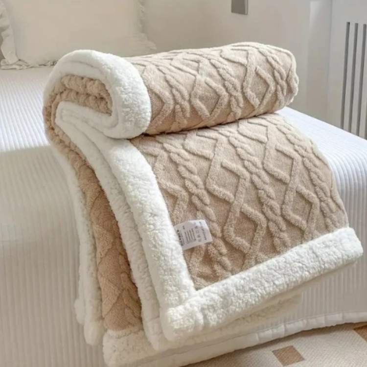 Sherpa weighted blanket in beige draped over a sofa