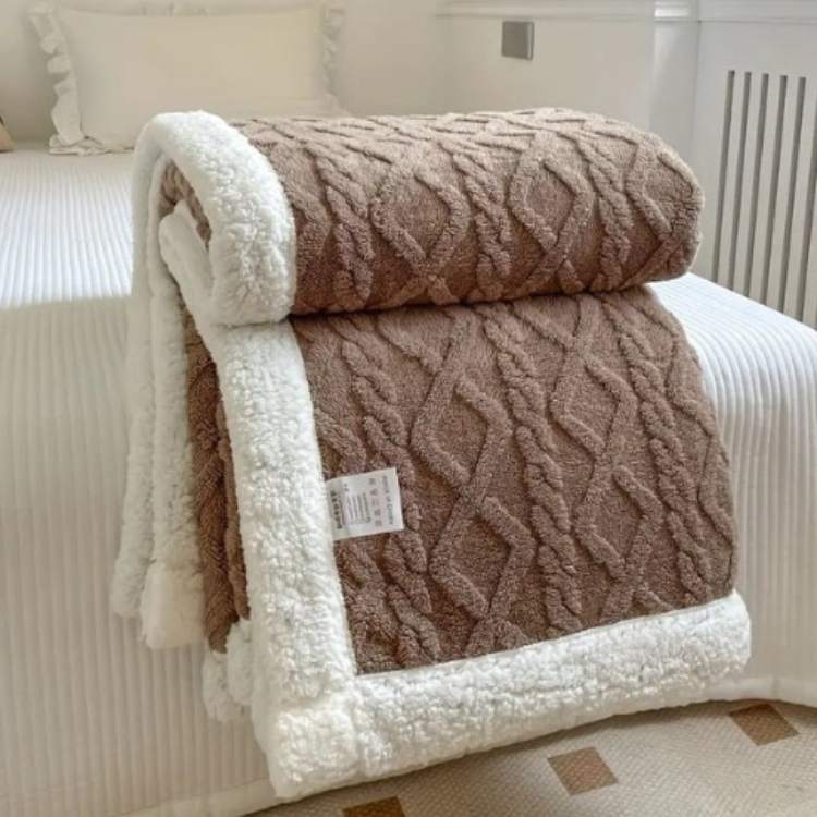 Sherpa weighted blanket in brown draped over a sofa