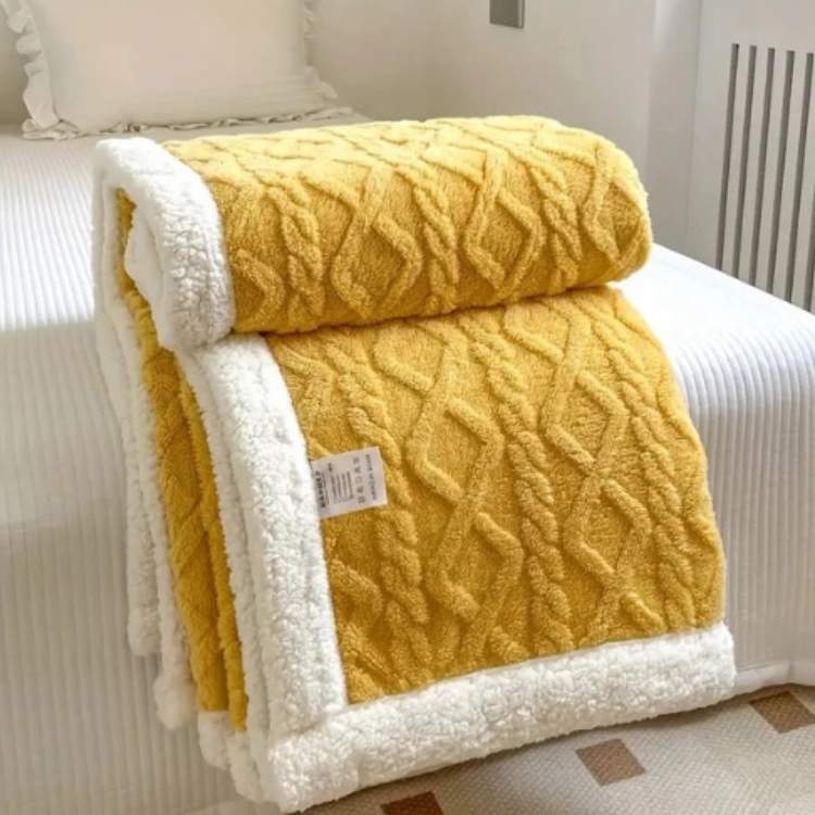 Sherpa weighted blanket in yellow draped over a sofa