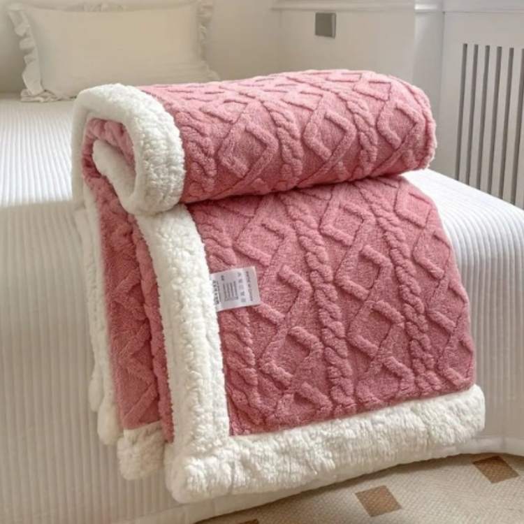 Sherpa weighted blanket in pink draped over a sofa