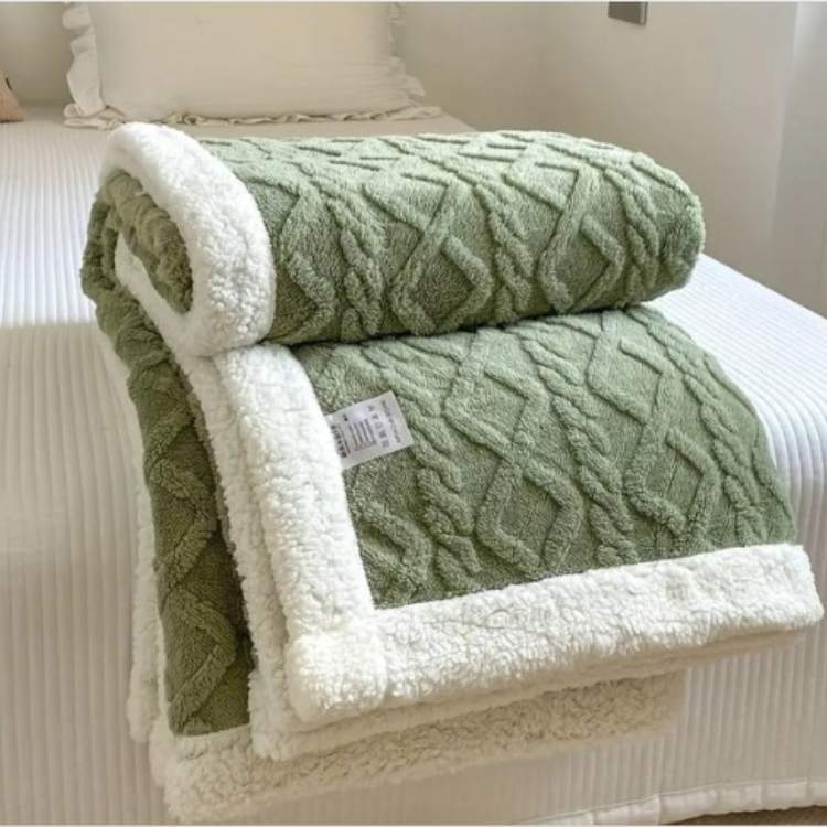 Sherpa weighted blanket in green draped over a sofa