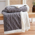 Sherpa weighted blanket in charcoal draped over a sofa