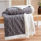 Sherpa weighted blanket in charcoal draped over a sofa