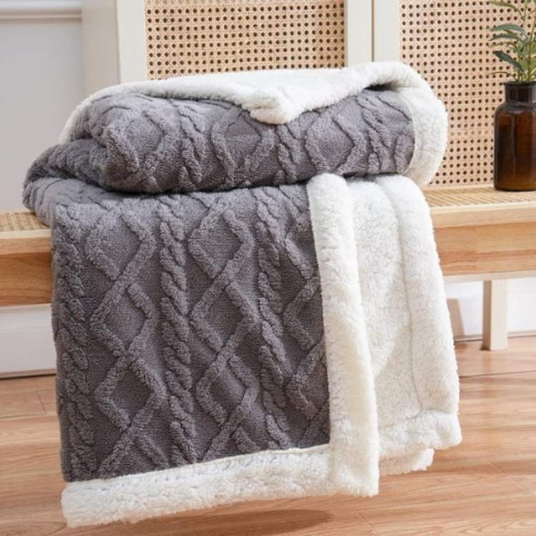 Sherpa weighted blanket in charcoal draped over a sofa