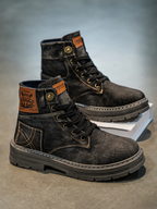 Pair of washed denim lace-up boots on a chunky rubber sole