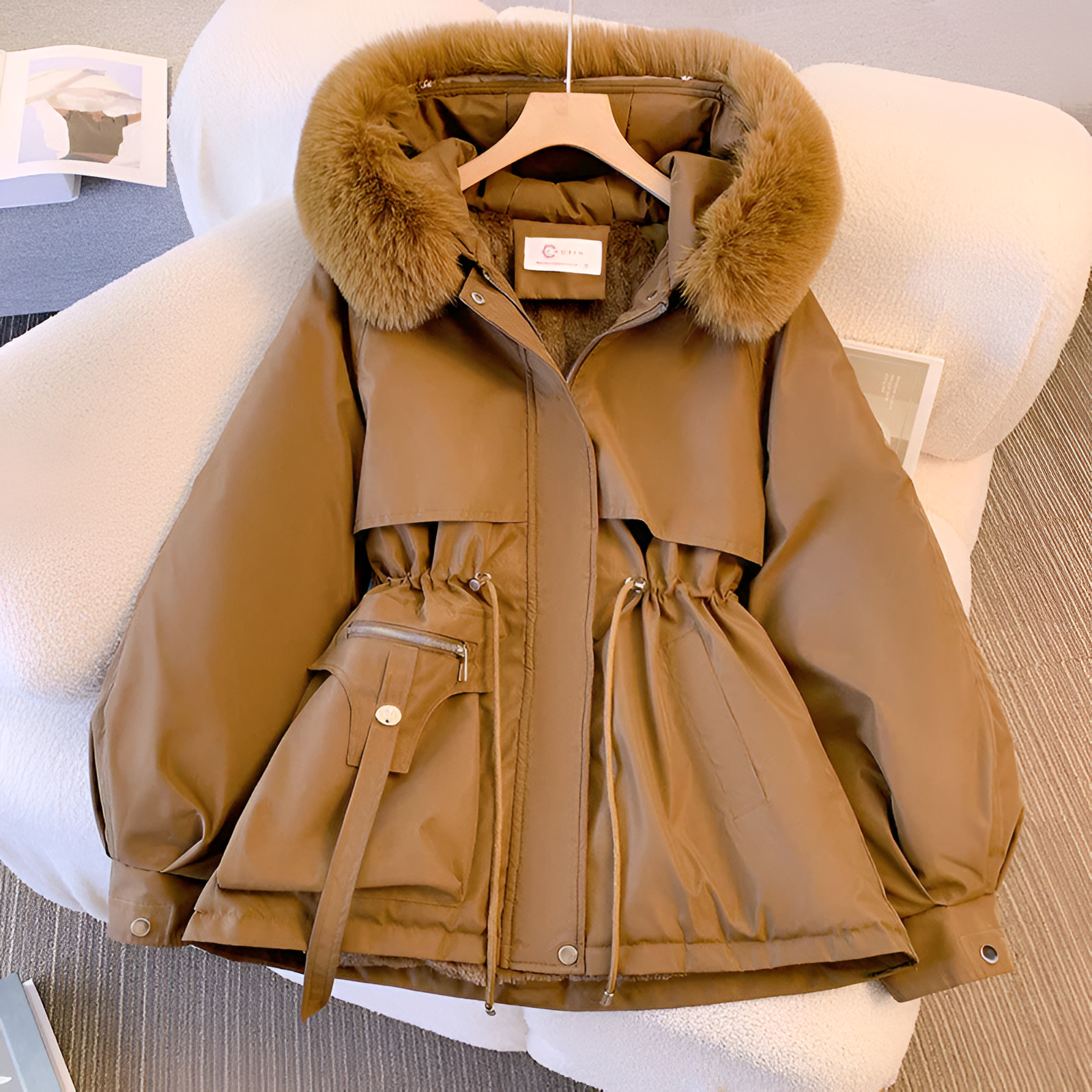 White hooded parka detail showing soft fleece lining and adjustable waist