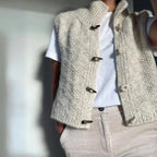Beige structured sleeveless vest styled as a layer, side view