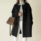 Minimalist collarless A-line winter coat in black.